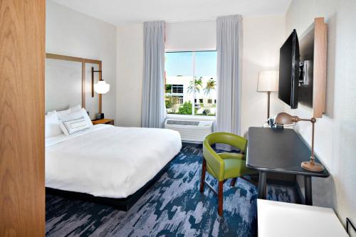迪爾菲爾德海灘的住宿－Fairfield by Marriott Inn & Suites Deerfield Beach Boca Raton，酒店客房配有一张床、一张桌子和一把椅子。