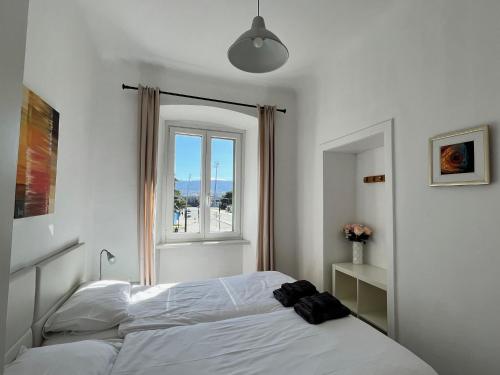 a bedroom with a white bed with a window at Casa Porta Muda in Koper