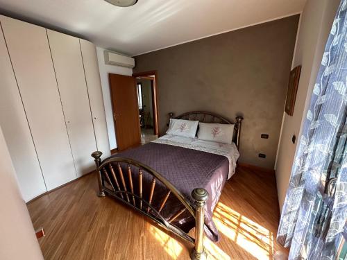 a small bedroom with a bed with a wooden floor at Casa Sabrina in Cernusco sul Naviglio