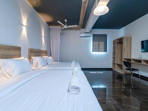 una camera con un grande letto bianco di The Ivory Suites a Mombasa