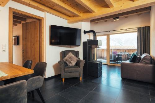 a living room with a tv and a table and chairs at Haus Piz Lad in Nauders