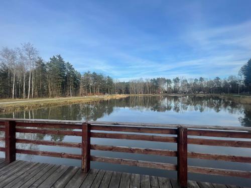 a bench on a dock near a lake at Hotel KARO in Radom