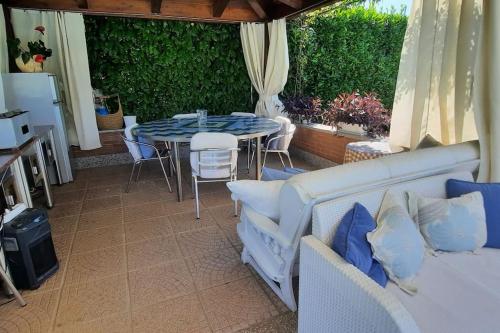a patio with a table and chairs and a couch at Villa Lara in Marsaglia
