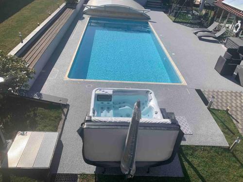 a boat sitting on the grass next to a swimming pool at Chalet 2 personnes avec jacuzzi privatif et piscine saisonnière partagée in Corcieux