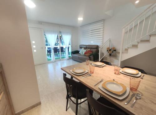 a living room with a table and chairs and a staircase at Casa Sete in Alcanar
