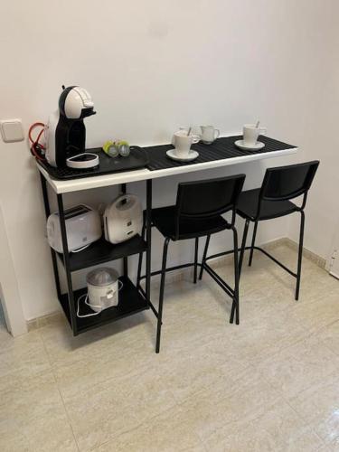 a black table with black chairs and cups on it at Casa Sete in Alcanar