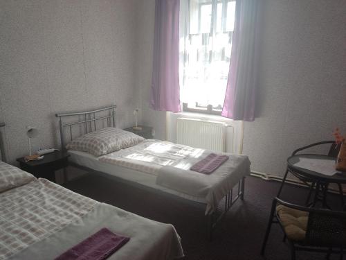 a hotel room with two beds and a window at Penzion U Soudu in Hora Svatého Šebestiána