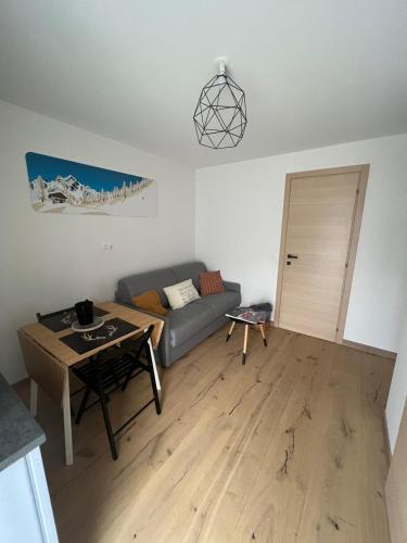 ein Wohnzimmer mit einem Sofa und einem Tisch in der Unterkunft Charmant studio Saint Gervais 74 in Saint-Gervais-les-Bains