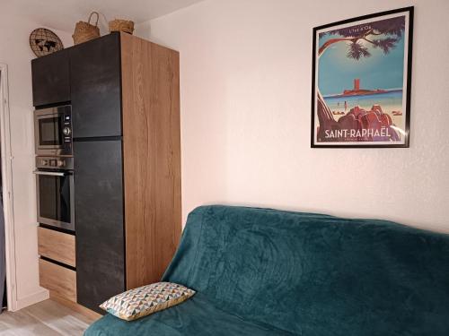 a living room with a green couch and a refrigerator at Studio Paradise entre mer et pins in Saint-Raphaël