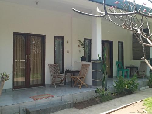 a porch of a house with chairs and a table at BUKIT GARDEN in Mataram