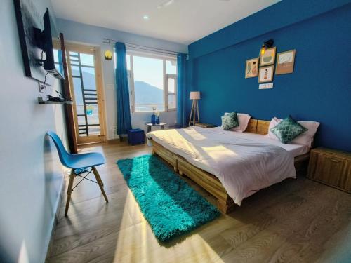 a blue bedroom with a bed and a blue wall at Blue Hills- B&B McleodGanj in Dharamshala