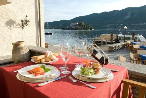 a table with plates of food and drinks on it at Hotel San Rocco in Orta San Giulio