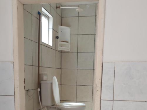 La salle de bains est pourvue de toilettes et d'une fenêtre. dans l'établissement Casa temporada Araçoiaba, 