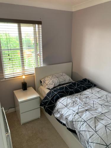 a small bedroom with a bed and a window at Thames River Side Townhouse in Thamesmead