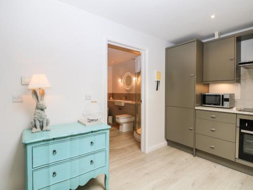 a kitchen with a blue dresser in a room at Rabbit's Warren in Warsash