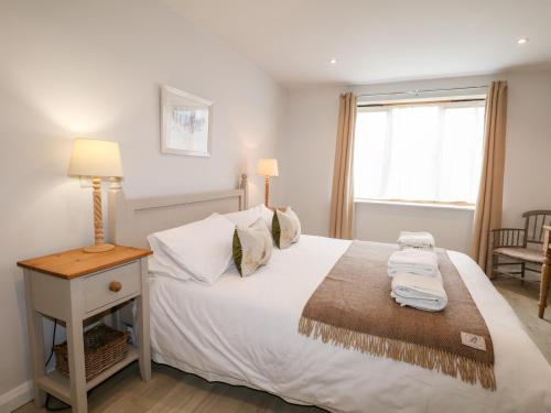 a bedroom with a large white bed and a window at Fox's Den in Fareham
