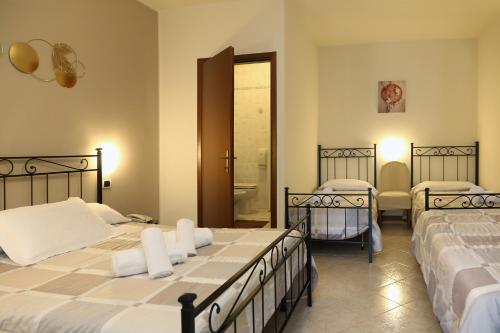 a bedroom with two beds and a bathroom at Hotel Andreis in Cavaion Veronese