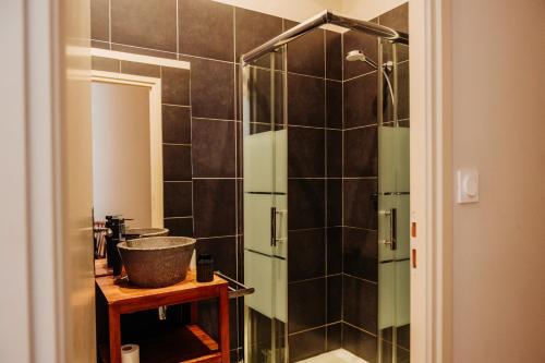 La salle de bains est pourvue d'une douche en verre et d'un lavabo. dans l'établissement La Maison de Gruissan, à Gruissan