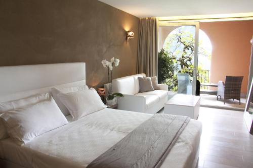 a bedroom with a white bed and a chair at Hotel San Rocco in Orta San Giulio