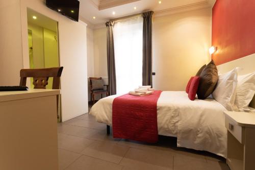 Il Piccolo Piacenza في بياتشينزا: غرفة فندق بسرير وبطانية حمراء