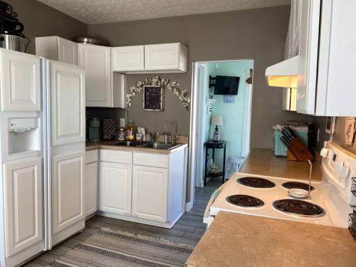 uma cozinha com armários brancos e um forno com placa de fogão em Solar Roof, eco-friendly home em Baltimore