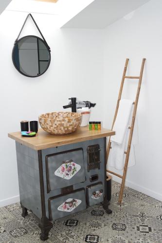 a mirror on top of a dresser with a sink at Logement de La Sittelle in Aizenay