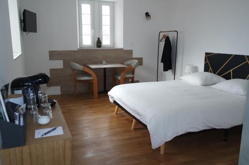 a bedroom with a bed and a table in it at Logement de La Sittelle in Aizenay