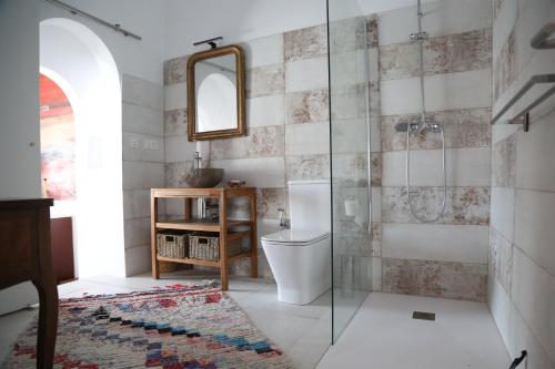 Un baño con inodoro y ducha de cristal. en Casa de la Fra, en Jerez de la Frontera