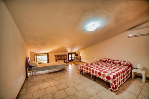 a bedroom with a bed and a couch at Villa Laura - Putzu Idu in Putzu Idu
