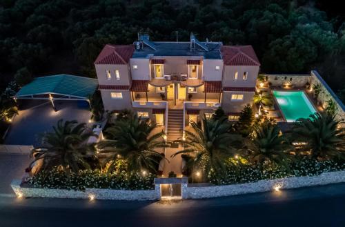 an aerial view of a house at night with a swimming pool at Evie's Houses in Kalathas