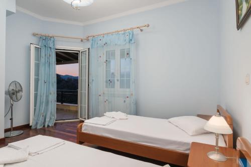 una camera con due letti e una finestra di Villa Vicky a Pythagóreion