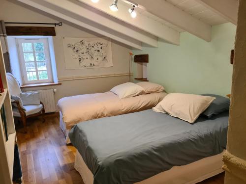 - une chambre avec deux lits, une chaise et une fenêtre dans l'établissement Domaine de la Basse Bobinière - Gîte et Chambres d'hôtes, à Thouarsais-Bouildroux