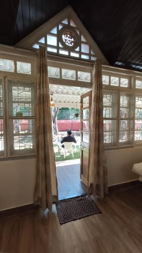 an open door in a room with a large window at Citadel Resort in Panchgani
