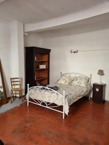 une chambre avec un lit blanc et une chaise dans l'établissement Appartement face au lac, à Bauduen