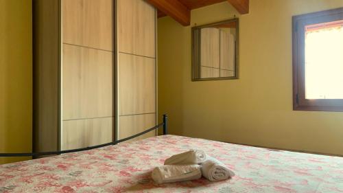1 dormitorio con 1 cama con toallas en Residenza Sophié, en Flumini di Quartu