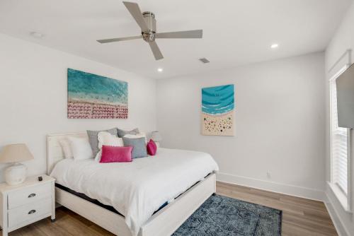 a white bedroom with a bed and a ceiling fan at The Eagles Nest in Rosemary Beach