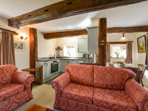 a living room with two couches and a kitchen at The Cottage in Moretonhampstead