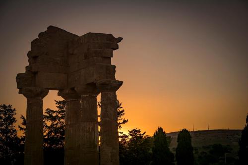 un pilar de piedra con la puesta de sol en el fondo en Atena apartments en Agrigento