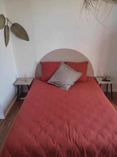 1 dormitorio con 1 cama roja y 2 mesas en La Provinciale en Ville en Montélimar