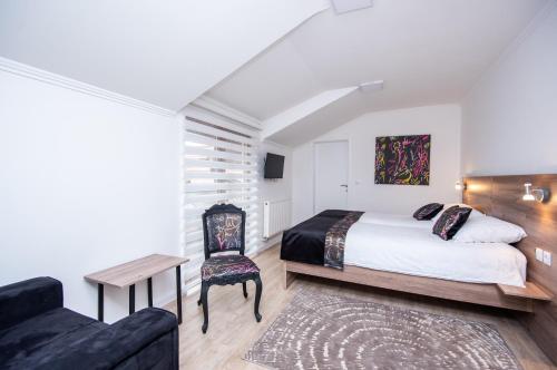1 dormitorio con 1 cama, 1 silla y 1 sofá en Guesthouse Bebek en Sarajevo