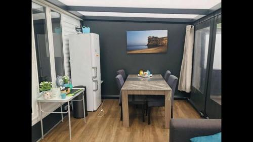 Chalet 4-6 personen op 5* camping Terspegelt في إيرسل: غرفة صغيرة مع طاولة وثلاجة