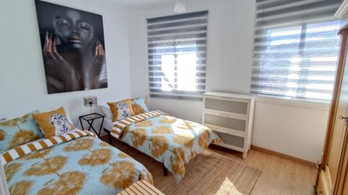 1 dormitorio con 2 camas y un cuadro en la pared en EMILY BEACH-CITY Apartment, en Montgat