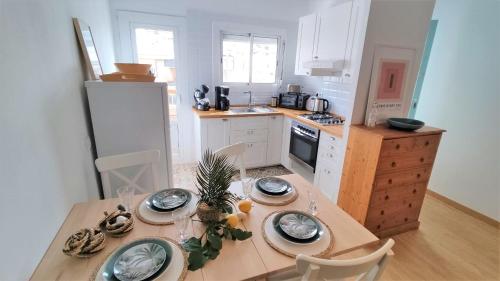 una cocina con una mesa de madera con platos. en EMILY BEACH-CITY Apartment, en Montgat