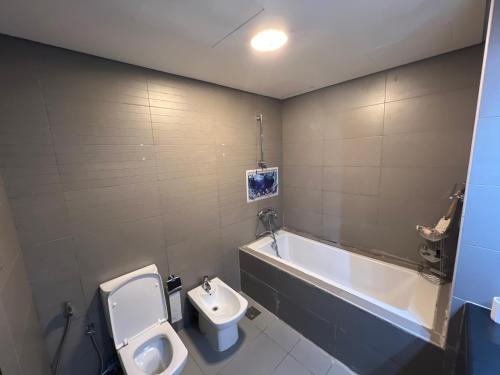 La salle de bains est pourvue de toilettes, d'un lavabo et d'un urinoir. dans l'établissement Prestigeo Guest House Abu Dhabi, à Abu Dhabi