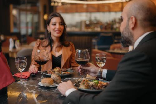 a group of people sitting around a table with wine glasses at Ramada by Wyndham Erbil Gulan Street in Erbil