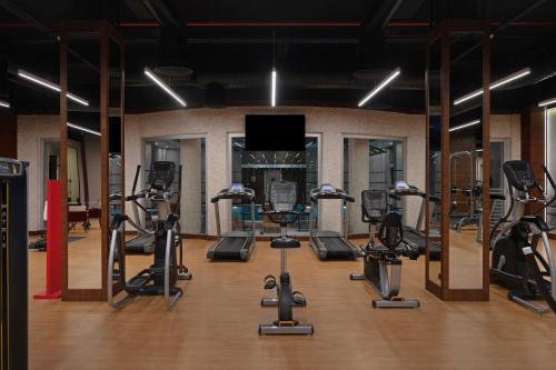 a gym with several treadmills and elliptical machines at Ramada by Wyndham Erbil Gulan Street in Erbil