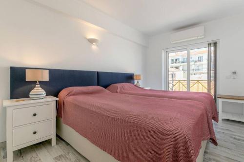1 dormitorio con 1 cama grande con manta roja en Casa Lilas, magnífica vista mar a passos da praia, en Luz
