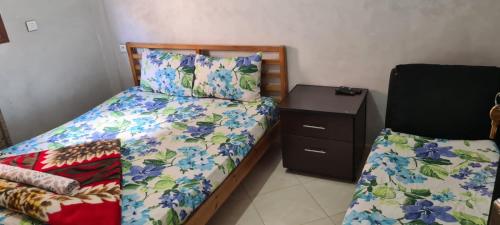 Habitación pequeña con cama y mesita de noche en chambres d'hôtes aéroport Mohammed V, en Deroua