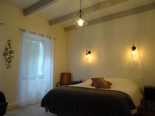 - une chambre avec un lit avec deux lumières et une fenêtre dans l'établissement La maison du Tour de Ville, à Cajarc