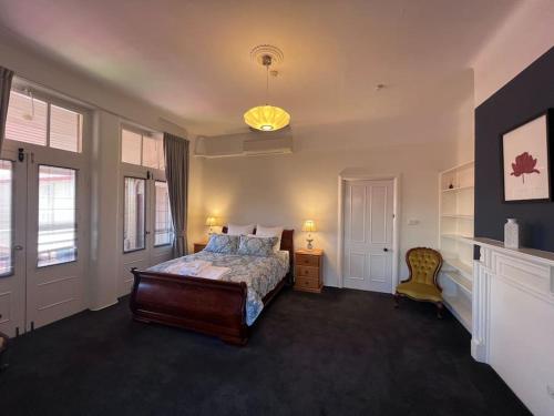 a bedroom with a bed and a chandelier at Arthurton Central in Hobart